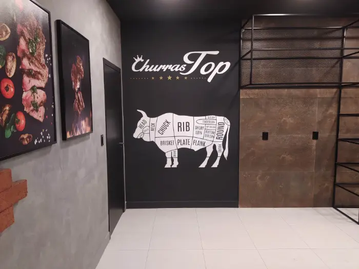 Adesivo de parede com logotipo e mapa ilustrado de cortes bovinos, em restaurante